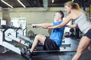 Personal trainer working with her client at a gym.